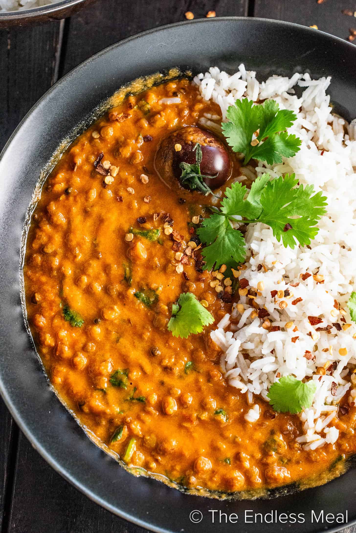 A close up of this coconut lentil curry recipe in a black bowl.