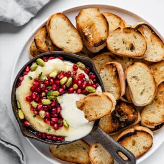 baked brie with pomegranate on a serving platter