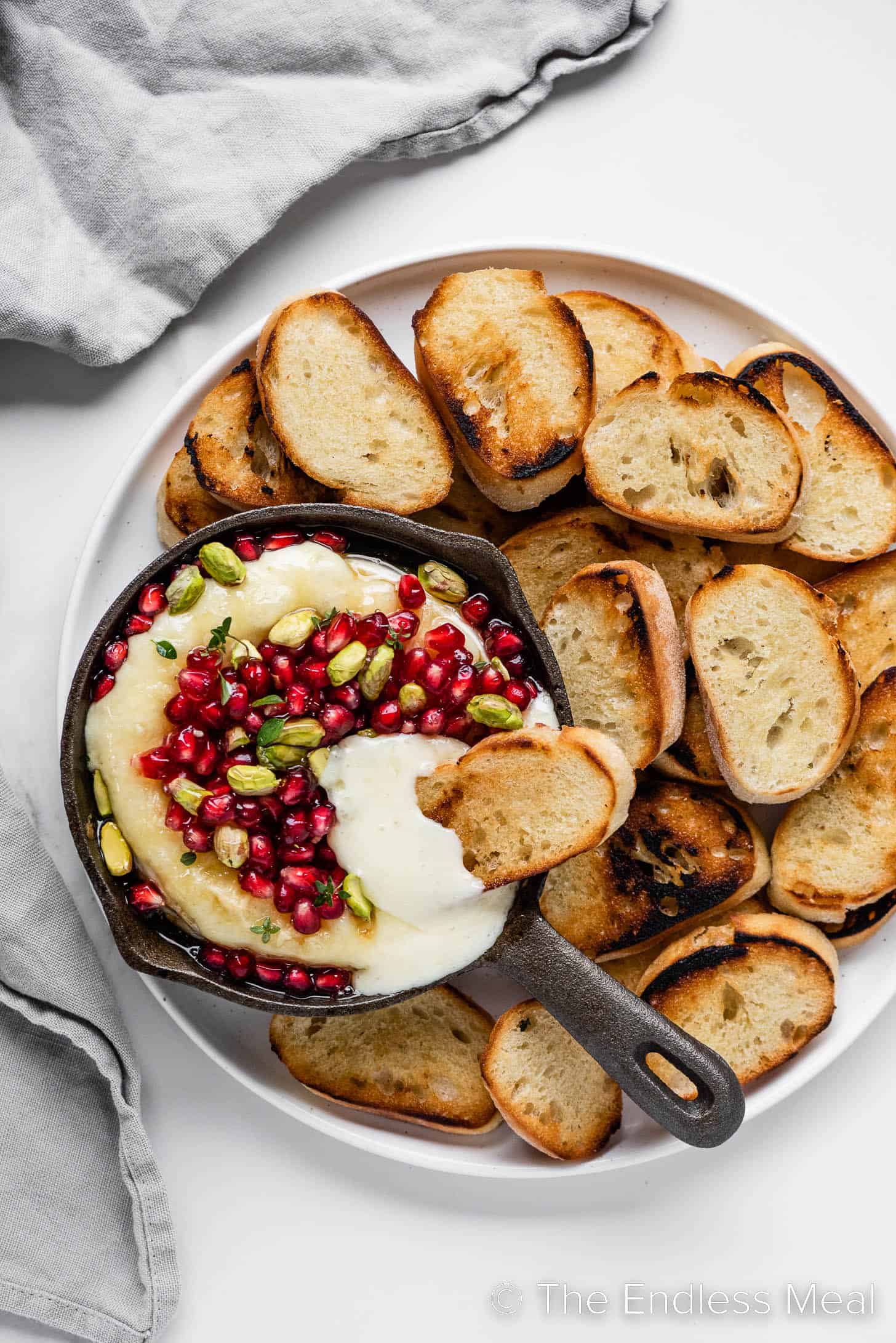 baked brie with pomegranate on a serving platter