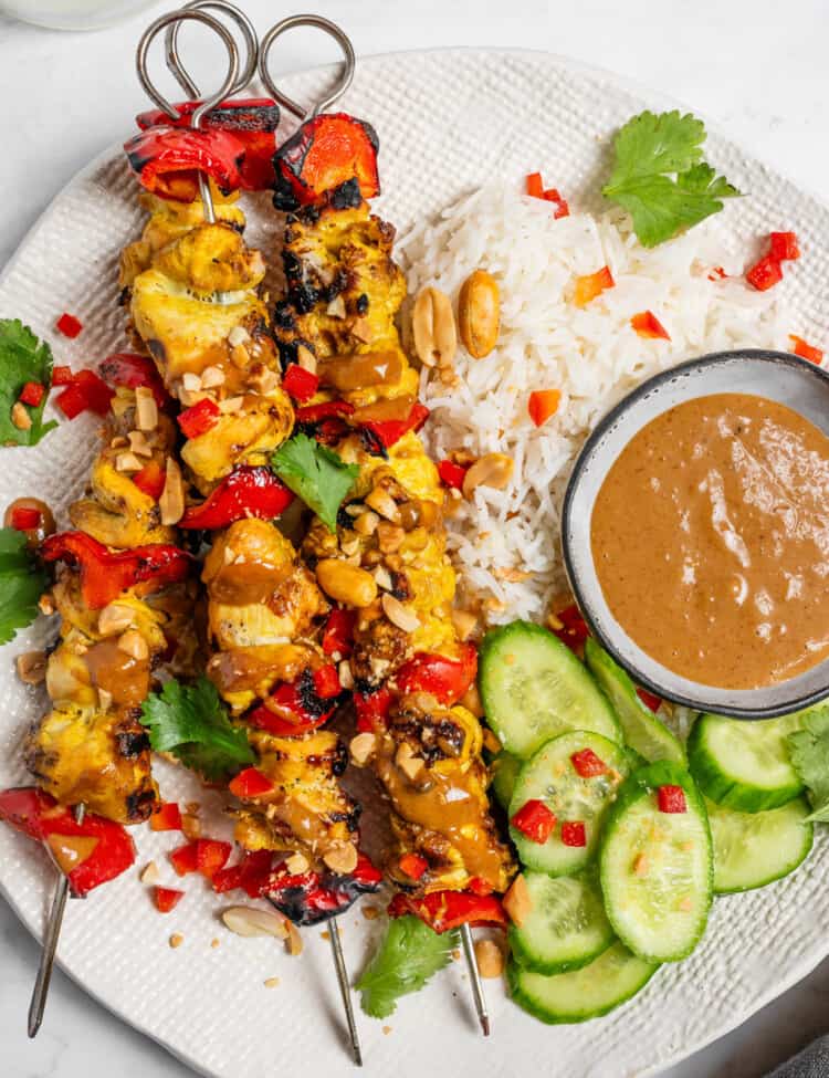 Chicken Satay Skewers on a dinner plate with rice