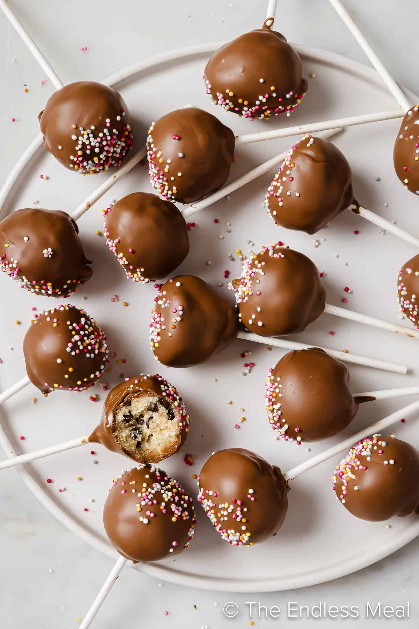 Cookie Dough Cake Pops on a white dessert serving plate.