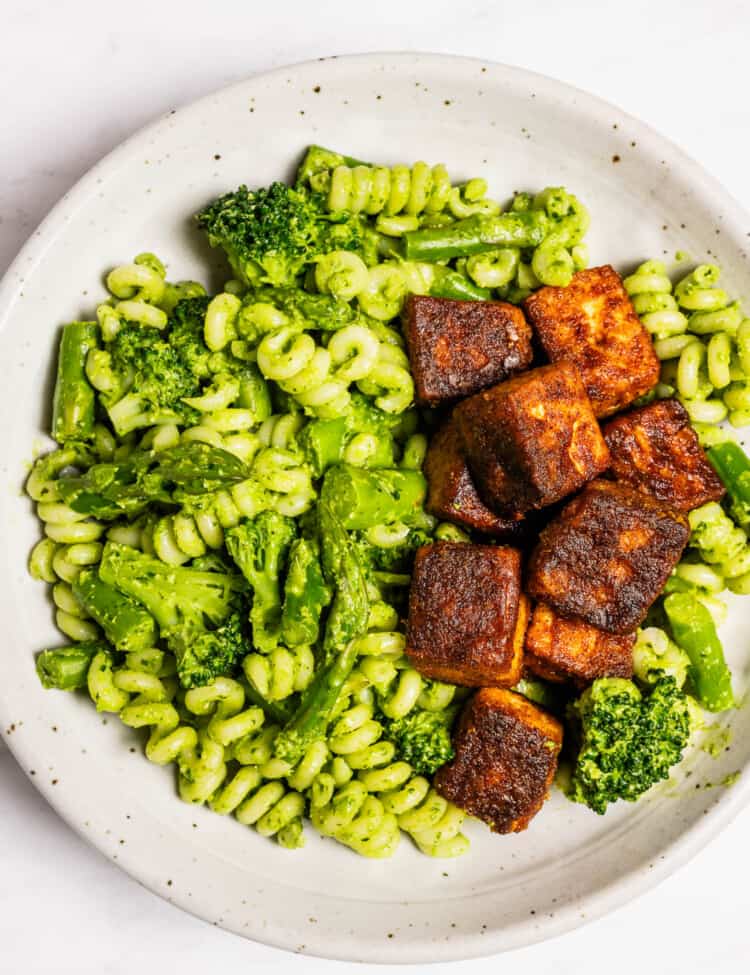 Green Pasta with crispy tofu in a dinner bowl.