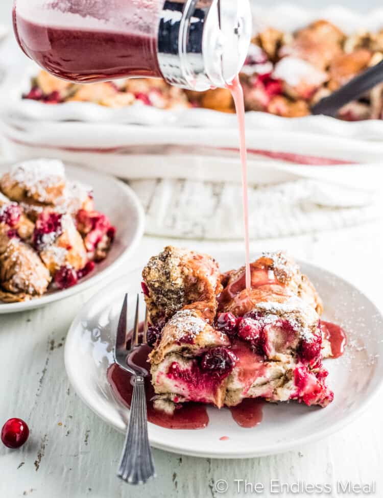 Vegan Christmas Breakfast french toast on a plate with cranberry syrup being poured over top.