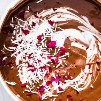 Mocha smoothie in a bowl with pink flowers on the top.
