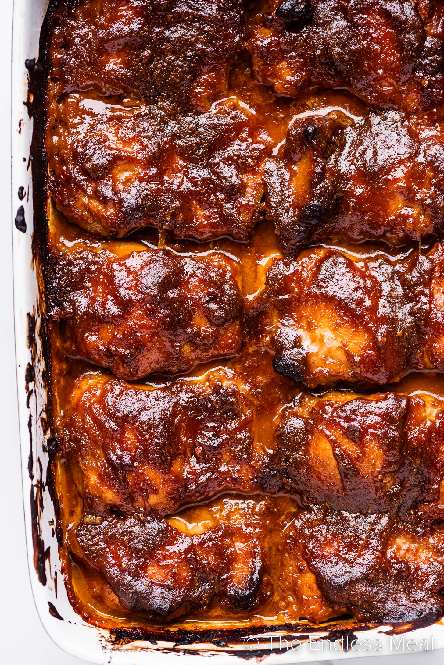 a pan of sticky Pomegranate Chicken thighs.