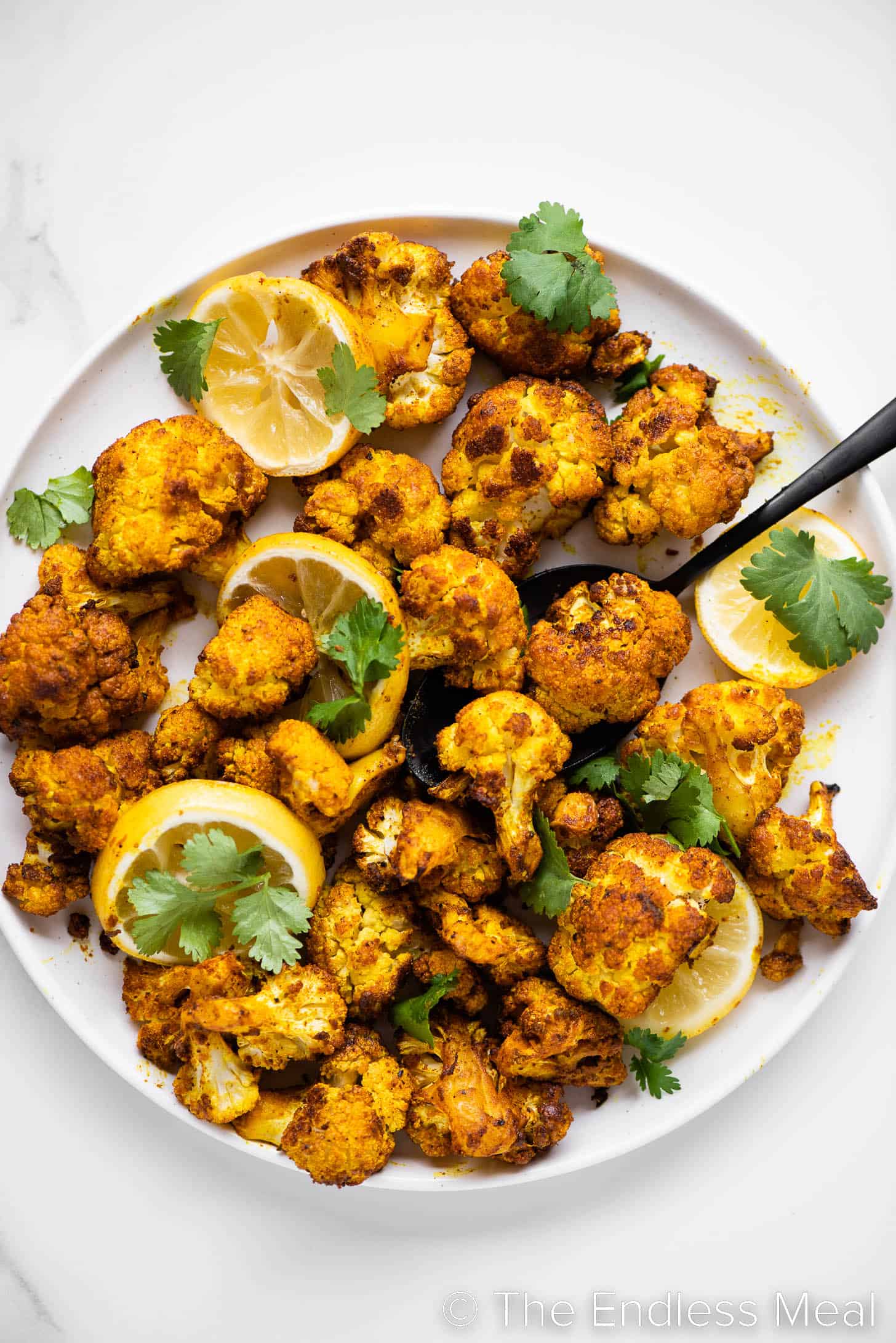 Turmeric Cauliflower on a serving platter with a spoon