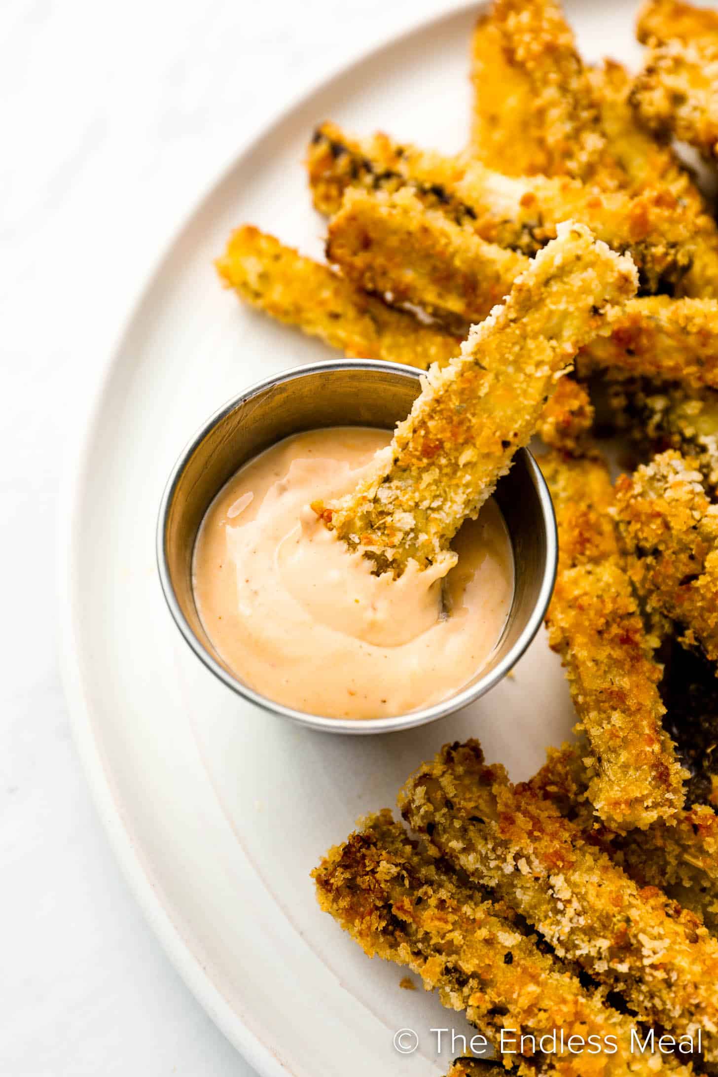 An Eggplant Fries being dipped into fry sauce