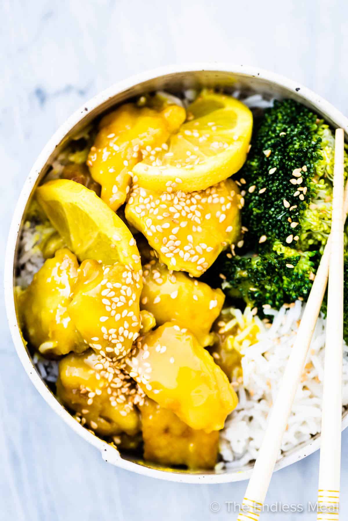 Lemon chicken bites in a bowl with rice and broccoli.