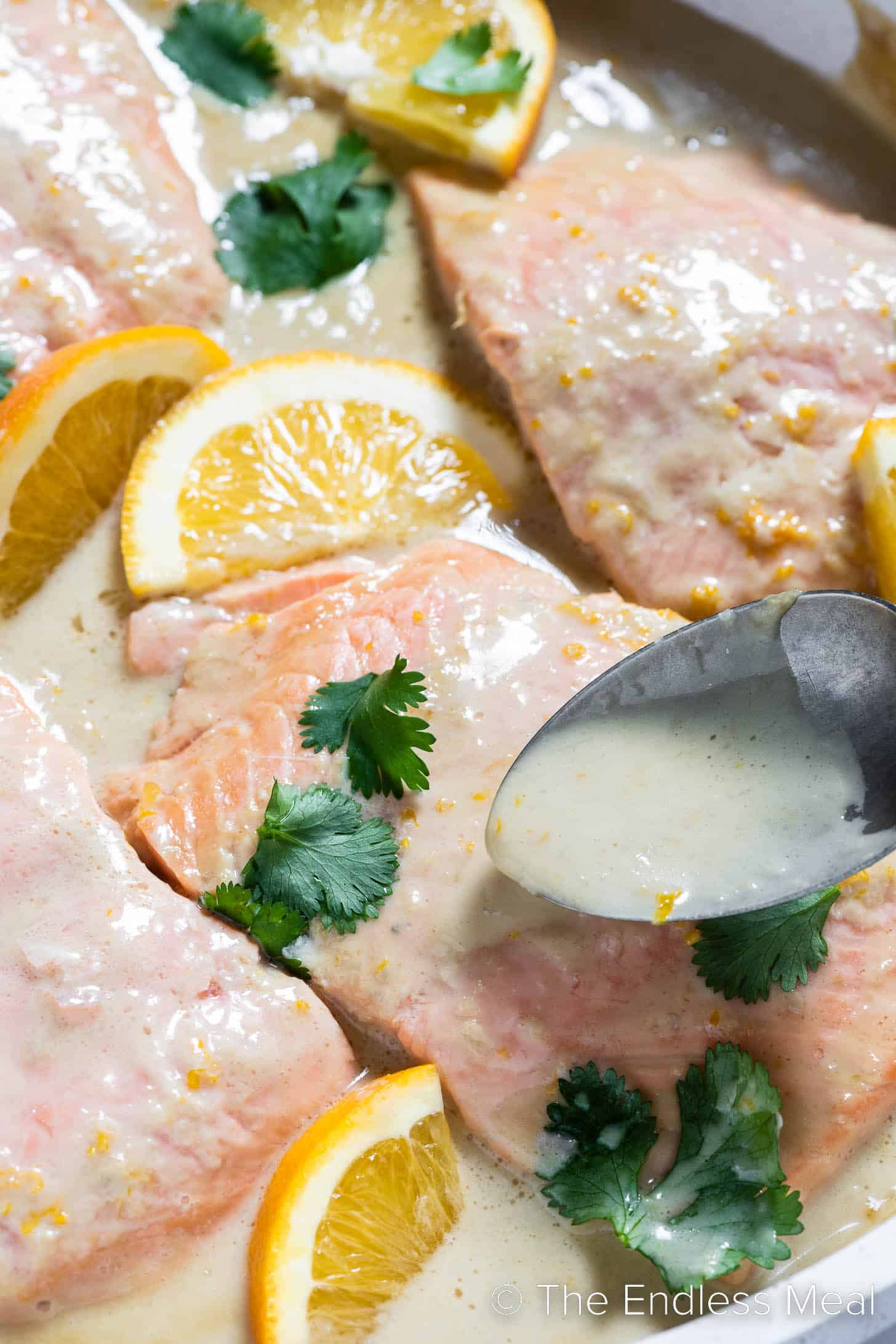 coconut sauce being spooned over poached salmon