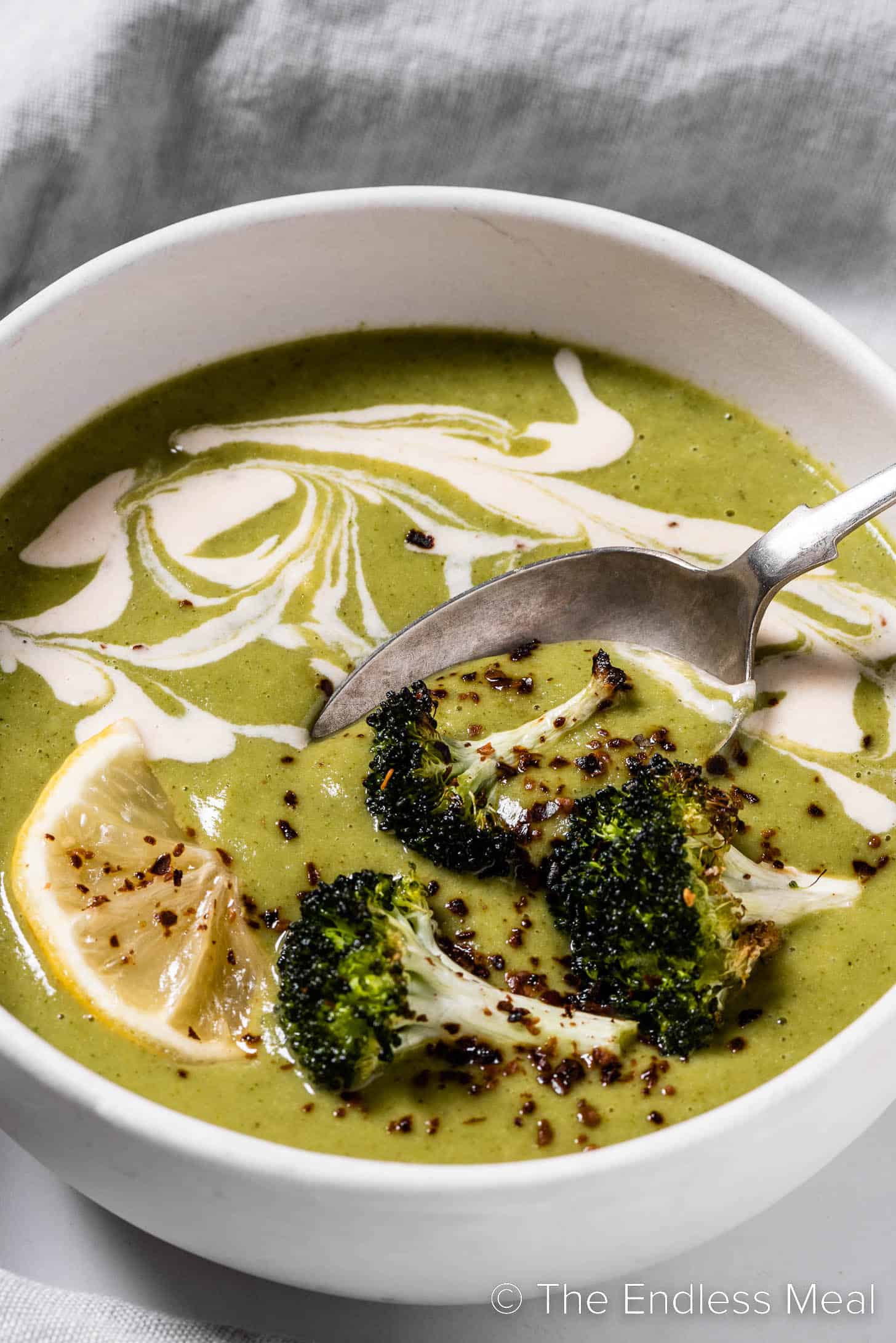 a closeup of a spoon in a bowl of Roasted Broccoli Soup.
