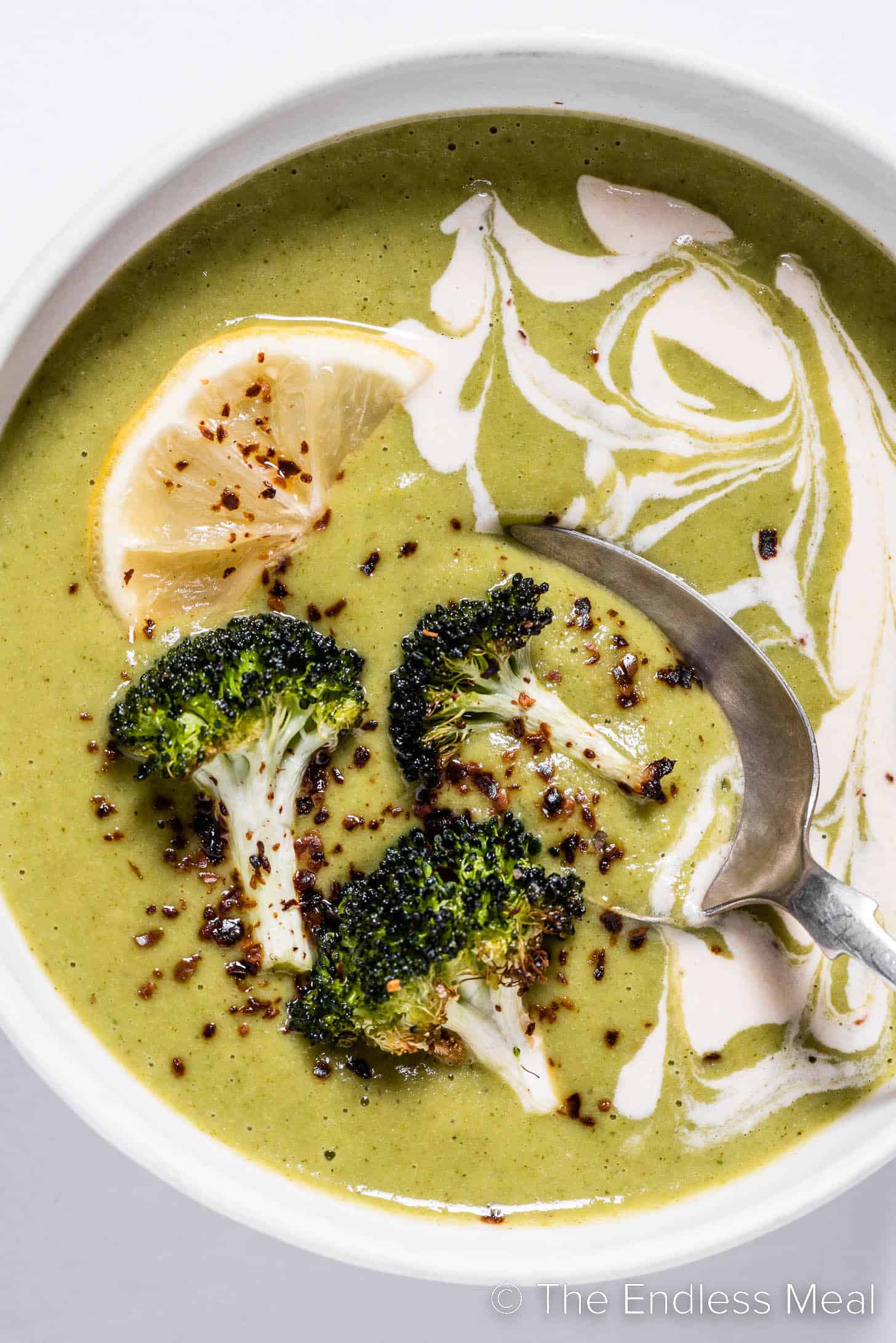 A close up of Roasted Broccoli Soup in a bowl with a spoon.