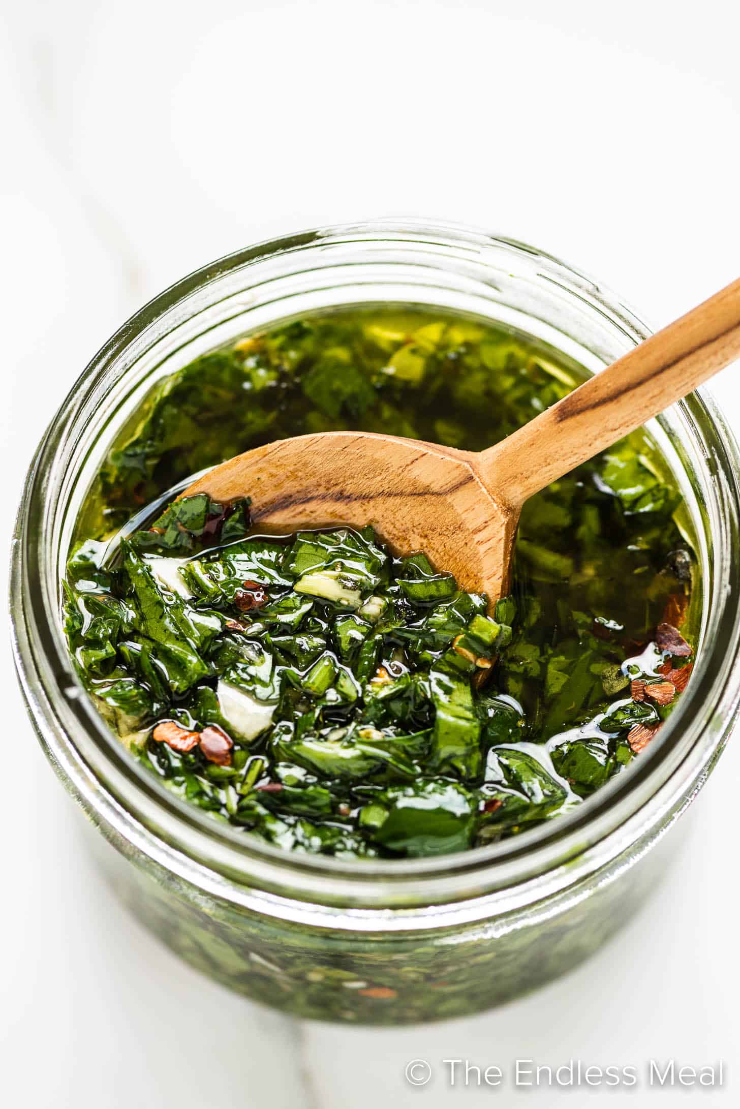 Chimichurri Sauce in a glass gar with a spoon