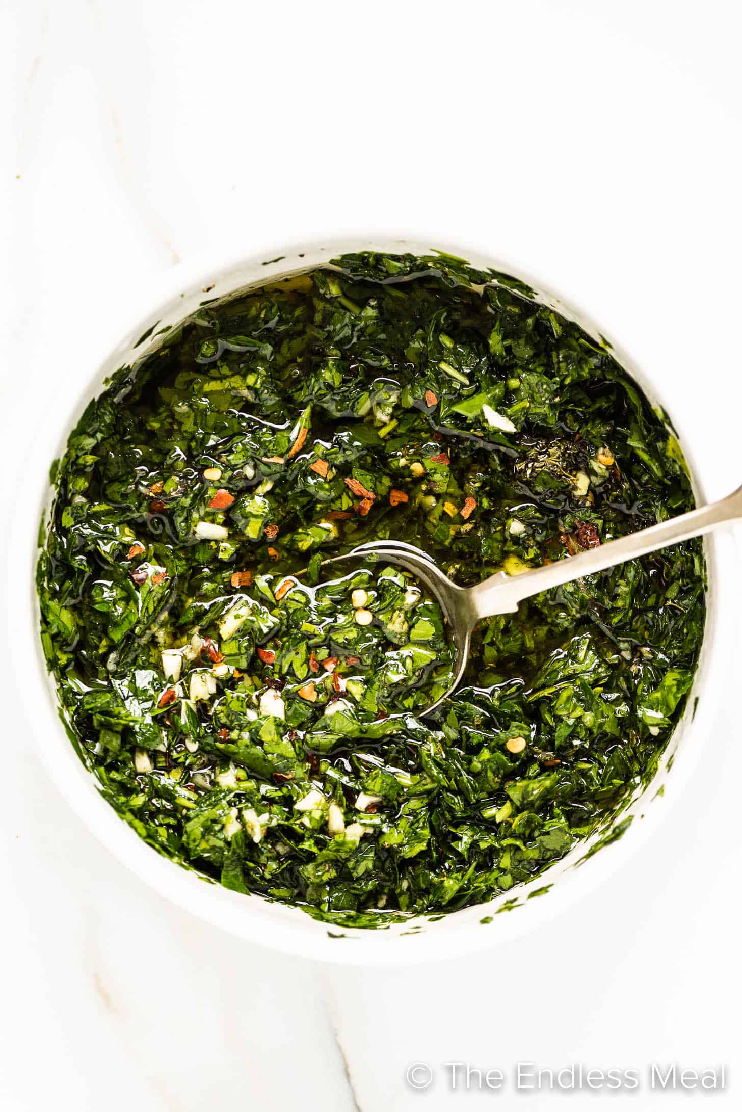 Chimichurri Sauce being mixed in a white bowl