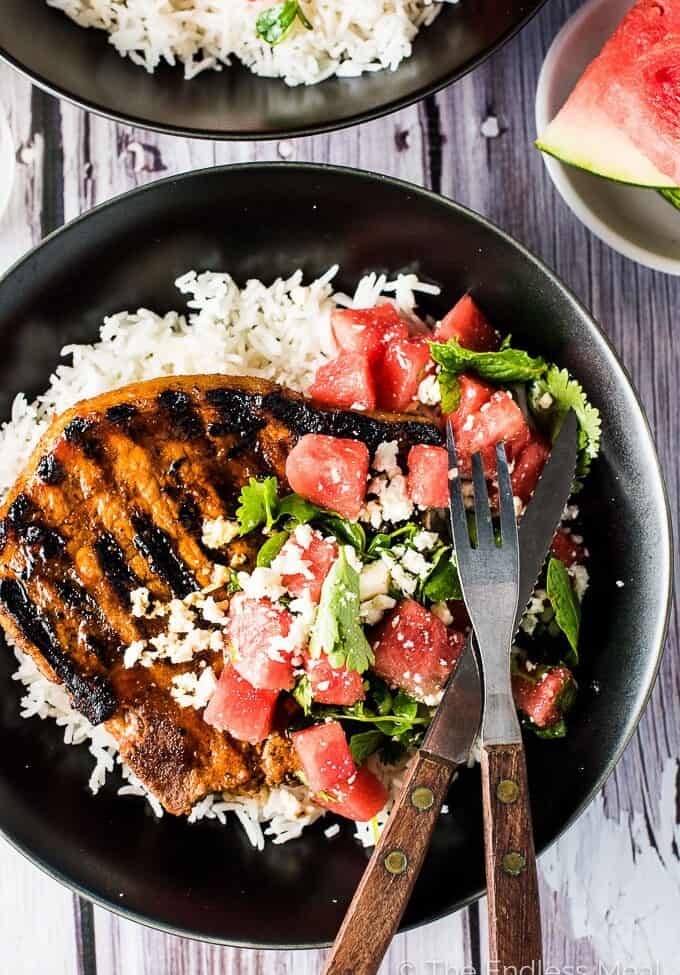 Grilled Gochujang Pork Chops are a delicious and healthy summer BBQ recipe. They are marinated in a sweet and spicy Korean chili paste then grilled to perfection. Serve them with a side of rice (or cauliflower rice!) and a simple mint watermelon salad for an easy and healthy dinner recipe. | theendlessmeal.com