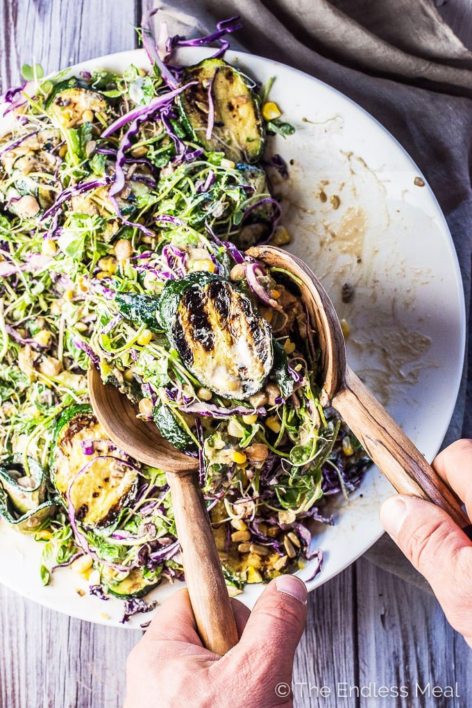 SAVE FOR LATER! This Grilled Zucchini Salad recipe is THE BEST salad ever. It's loaded with summertime favorites like grilled zucchini and corn, alfalfa sprouts, purple cabbage, and healthy chickpeas and tossed in a super creamy and easy to make sunflower seed dressing.  | vegan + gluten-free + refined sugar-free | #theendlessmeal #salad #zucchini #zucchinirecipes #bbq #grill #corn #sunflowerseeds #vegan #glutenfree
