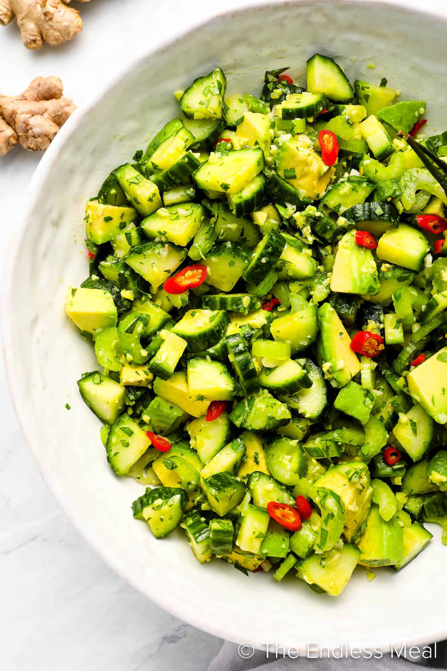 A close up of cucumber avocado salad in a serving dish