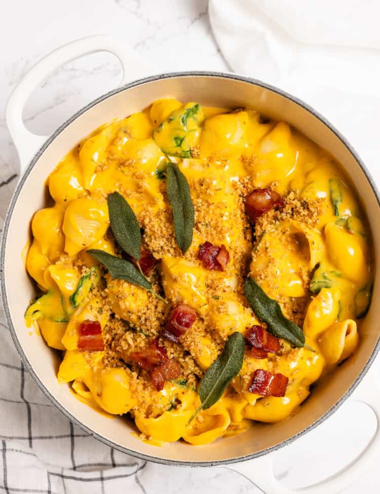 Pumpkin Mac and Cheese in a white pot with bacon and sage