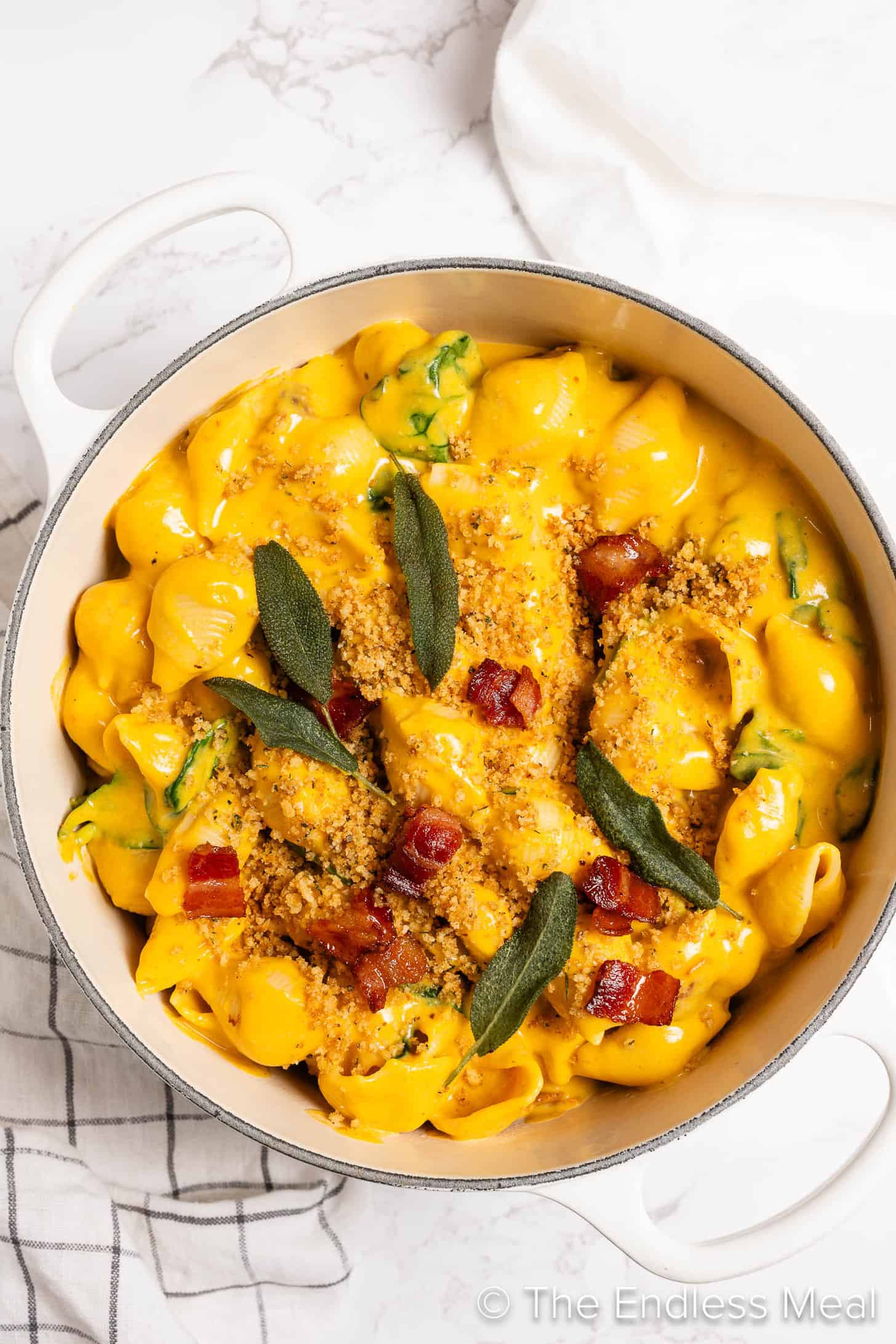 Pumpkin Mac and Cheese in a white pot with bacon and sage
