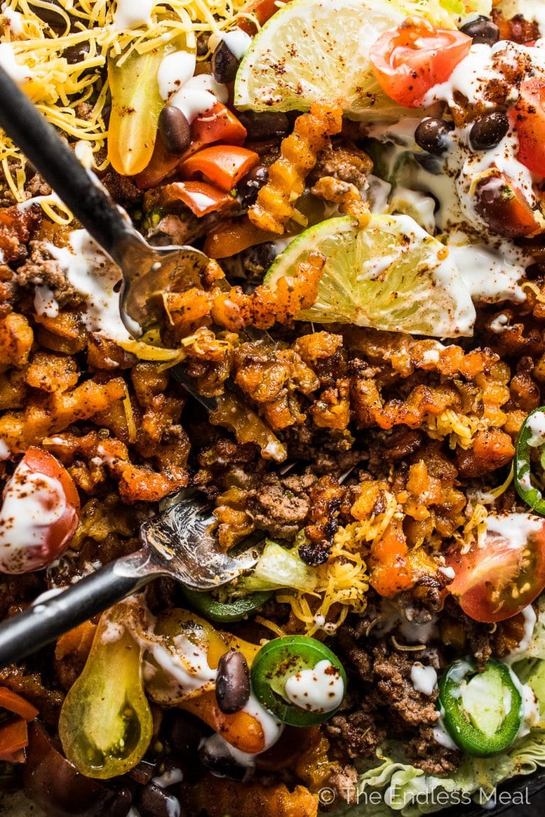 Looking for the best healthy-ish French fry recipe ever? These loaded Taco Salad Fries are it! They're made with super fun butternut squash zig zags and are piled high with all your favorite taco salad ingredients. Serve these as a Super Bowl appetizer or a delicious, kid-friendly dinner. You love them! | theendlessmeal.com | #superbowl #fries #frenchfries #tacosalad #partyappetizer #culinarycuts #butternutsquash 