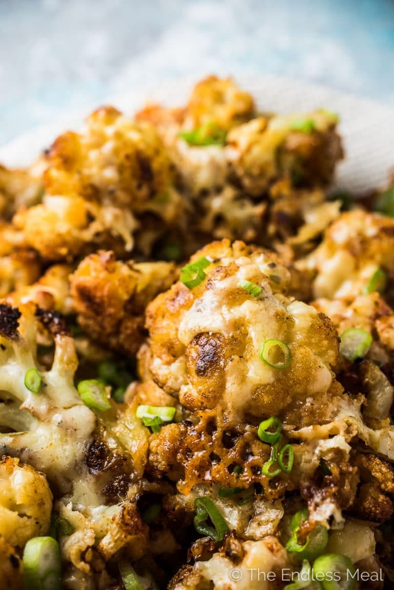 This insanely delicious Irish Cheddar Cauliflower is first tossed in spices and roasted in the oven. Then it's topped with Irish cheddar popped back in the oven until it melts. It's like cauliflower with cheese sauce only a thousand times better. | vegatarian + gluten-free | thendlessmeal.com | #cauliflowerrecipes #stpatricksday #irishrecipes #cauliflower #vegetarianrecipes #glutenfreerecipes