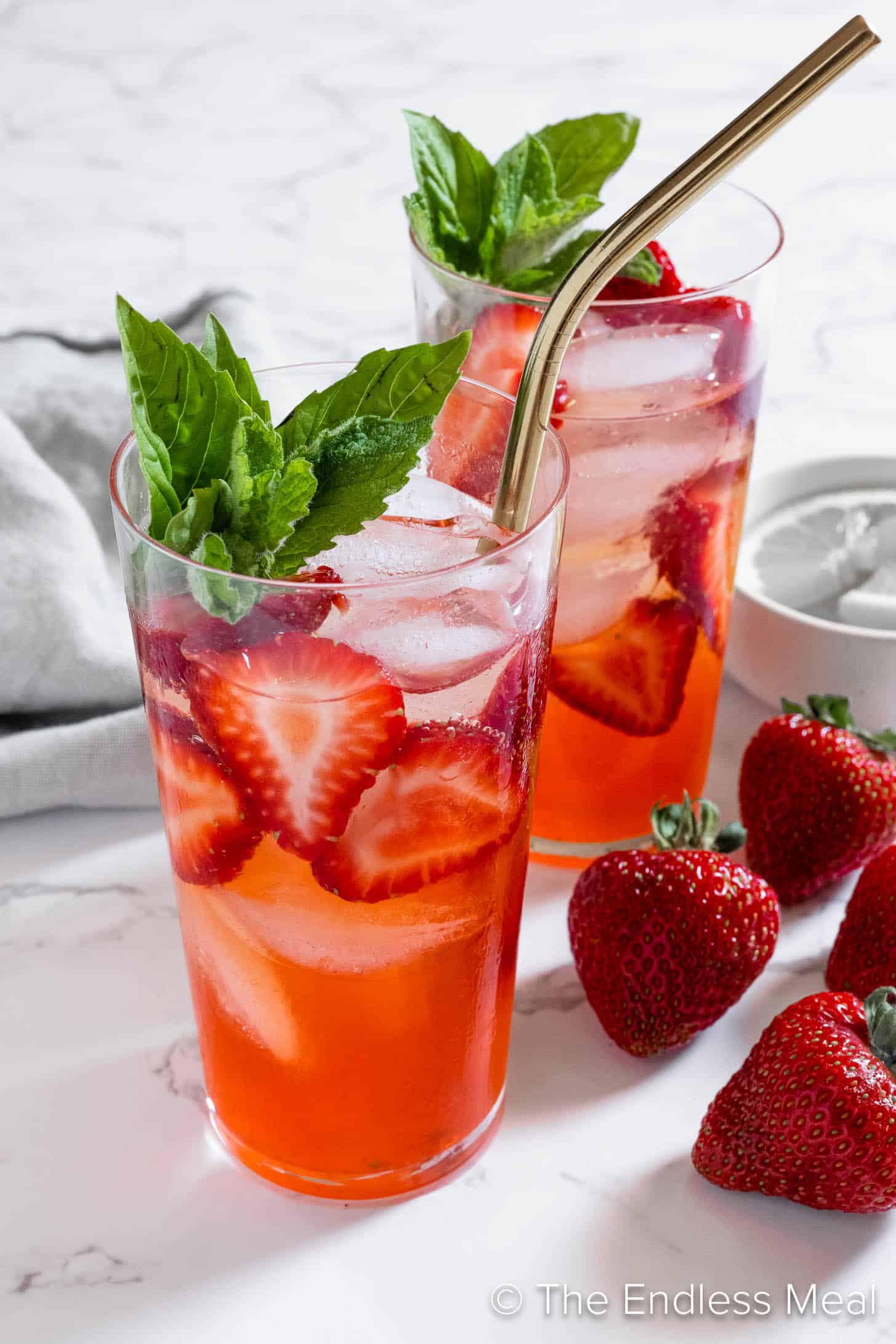 A Strawberry Mojito cocktail in a glass with a straw