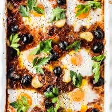 Spanish Baked Eggs is made with a rich tomato sauce with whole cloves of roasted garlic and lots of plump, black Hojiblanca Olives from Spain. Eggs are baked into the sauce which is just as delicious eaten for dinner as it is for breakfast. | gluten-free + paleo + Whole30 + vegetarian option | #theendlessmeal #eggs #spanisheggs #olives #bakedeggs #breakfast #brunch