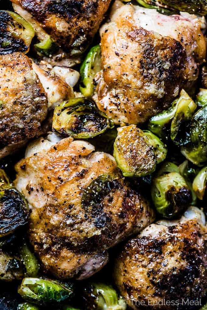 Looking down on a pan of crispy skinned garlic butter chicken and brussels sprouts. 