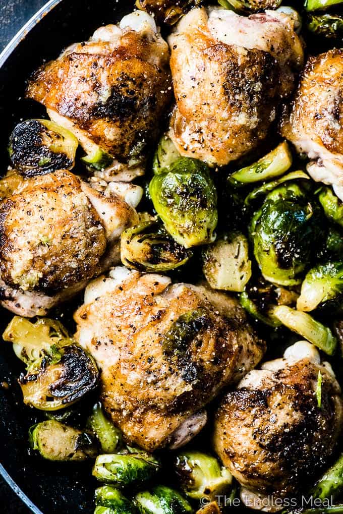 Looking down on a pan of crispy skinned garlic butter chicken and brussels sprouts. 