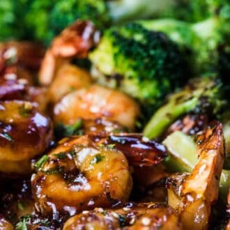 Sticky sesame honey shrimp in a pan with ginger broccoli.