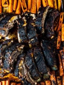 SAVE FOR LATER! Blackened Ribs with Caramelized Carrots is a ridiculously delicious and easy to make dinner recipe. The black and orange color scheme makes it perfect for a fall/ Halloween dinner, but you're going to want to make them again all winter long. | gluten-free + refined sugar-free + paleo | #theendlessmeal #ribs #porkribs #backribs #spareribs #sheetpandinner #onepandinner #paleo #glutenfree #refinedsugarfree #halloween #fall #fallrecipes #healthyrecipes #carrots #blackened