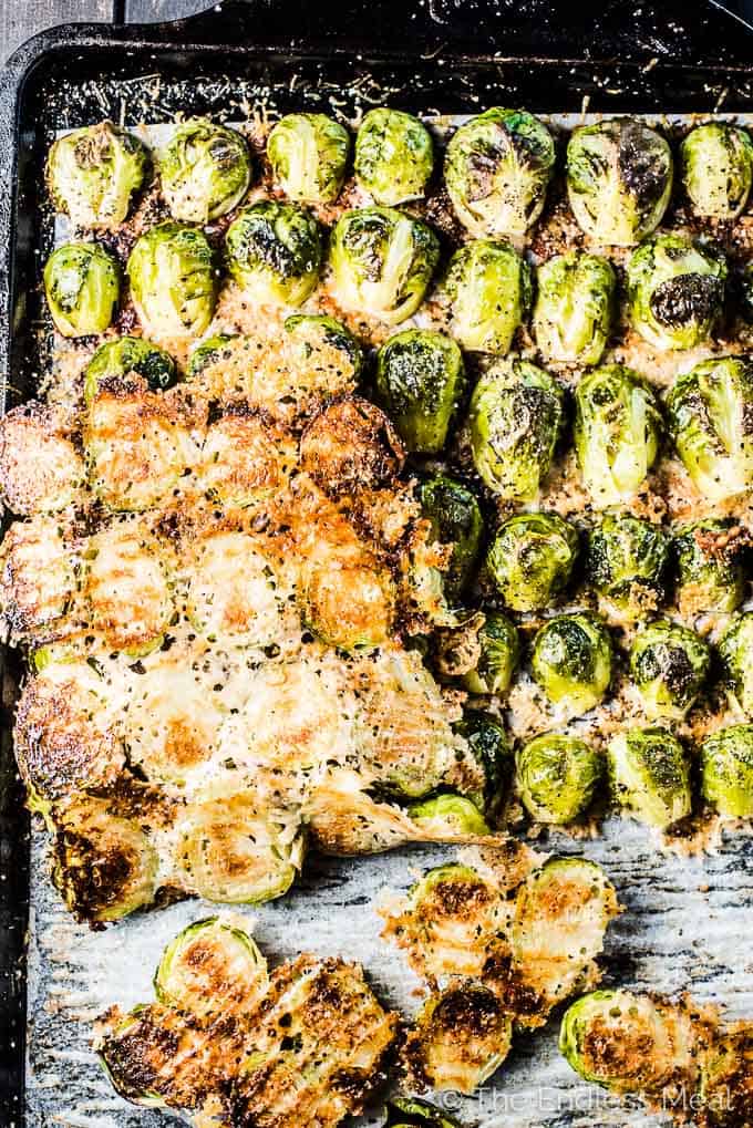 A sheet pan with parmesan brussels sprouts with half the brussels folded up so you can see the cheese melted onto them. 