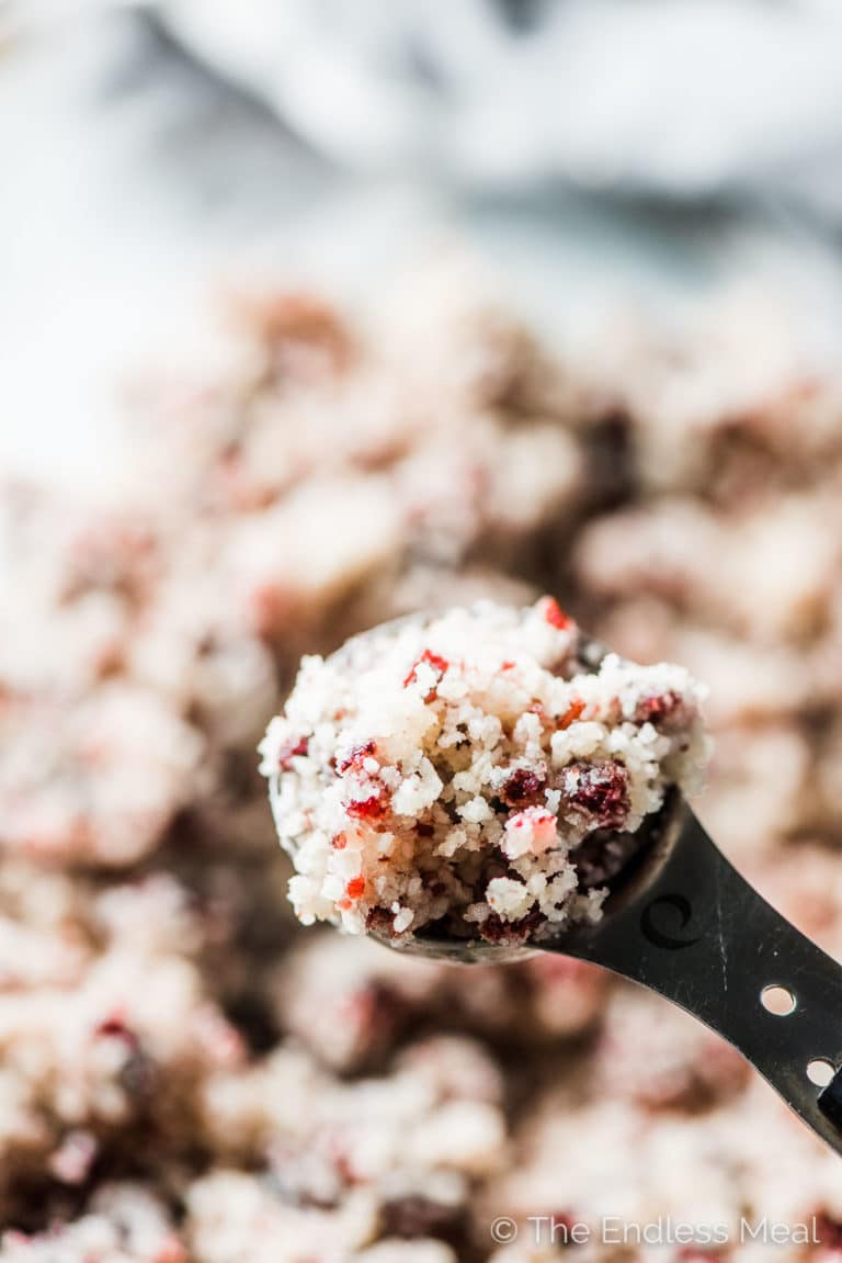 A close up of a cookie scoop with the Cranberry Coconut Macaroons batter in it. 