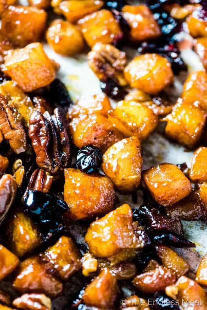 Maple roasted butternut squash with cranberries and pecans on a baking sheet.