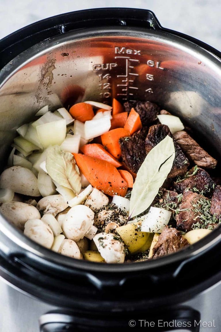 Looking into an Instant Pot filled with all the ingredients to make Instant Pot Paleo Beef Stew. 