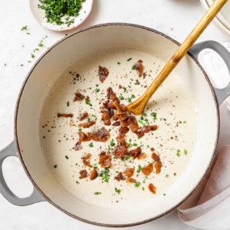 A pot of Paleo Cauliflower Soup with bacon on top