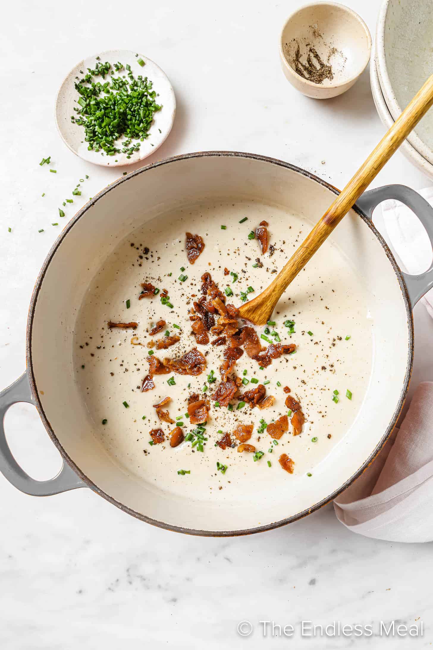 A pot of Paleo Cauliflower Soup with bacon on top