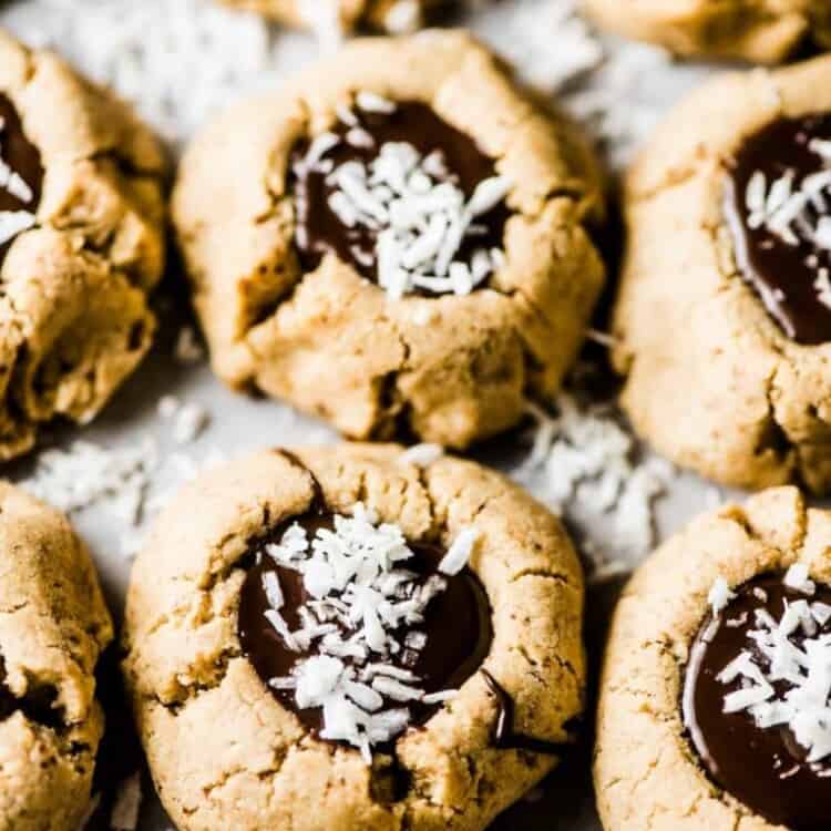 Chocolate Almond Thumbprint Cookies on a tray with coconut sprinkled over top of them.