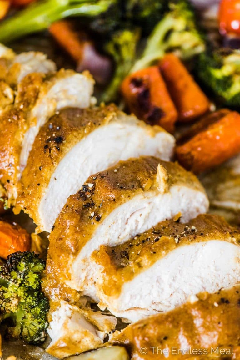 A close up of Sheet Pan Faux Honey Mustard Chicken with the chicken sliced into pieces. 