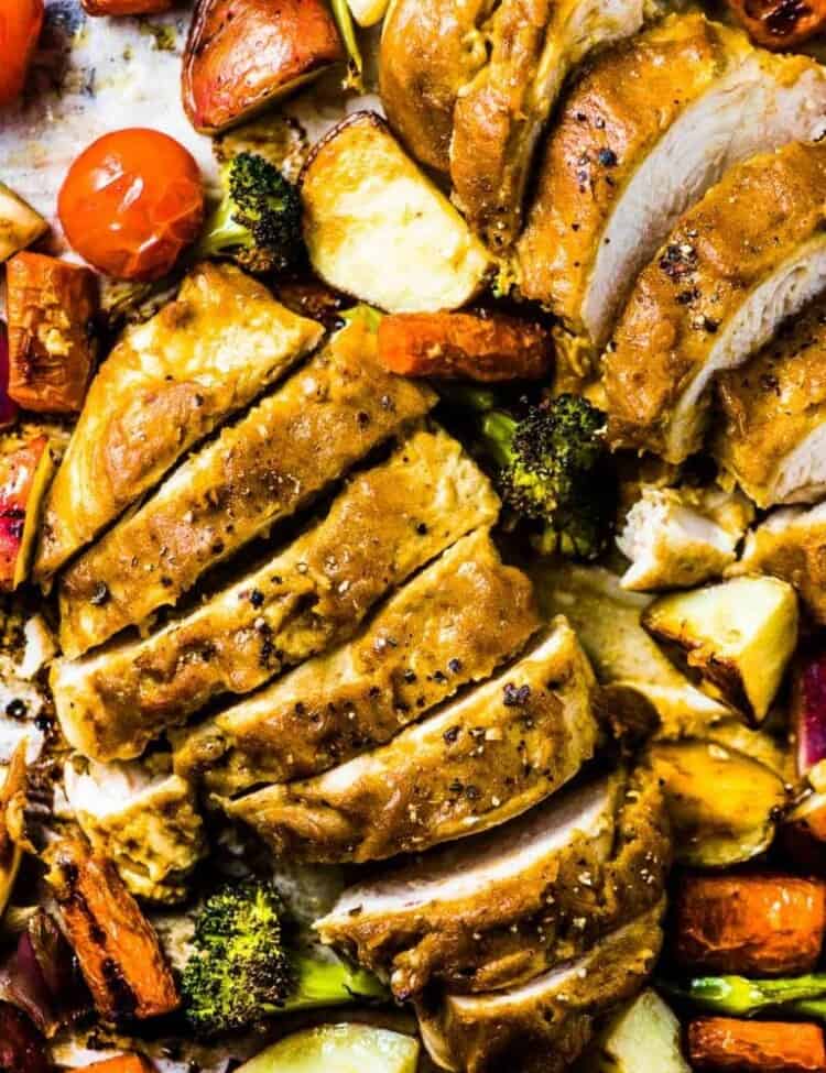 A close up of Sheet Pan Faux Honey Mustard Chicken with the chicken sliced into pieces.