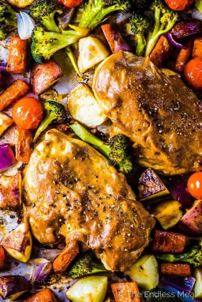 Looking down on a pan of Sheet Pan Faux Honey Mustard Chicken with lots of veggies.