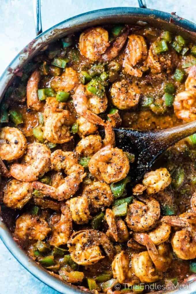 Looking down on a skillet of spicy shrimp and green peppers.