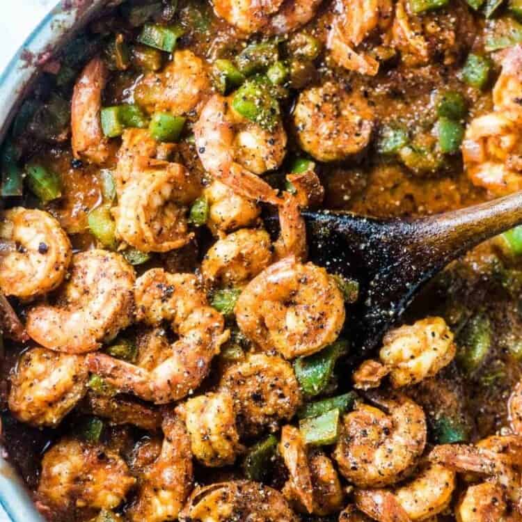 Looking down on a skillet of spicy shrimp and green peppers.