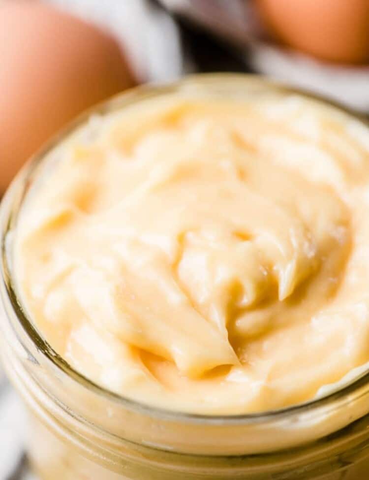 Thick homemade mayonnaise in a glass jar.