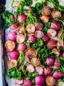 Miso Butter Roasted Radishes and radish greens on a baking sheet.