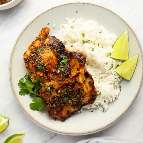 Cilantro Lime Chicken on a white plate with rice and sliced limes
