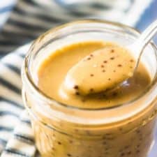 Creamy balsamic vinaigrette in a glass jar with a spoon.
