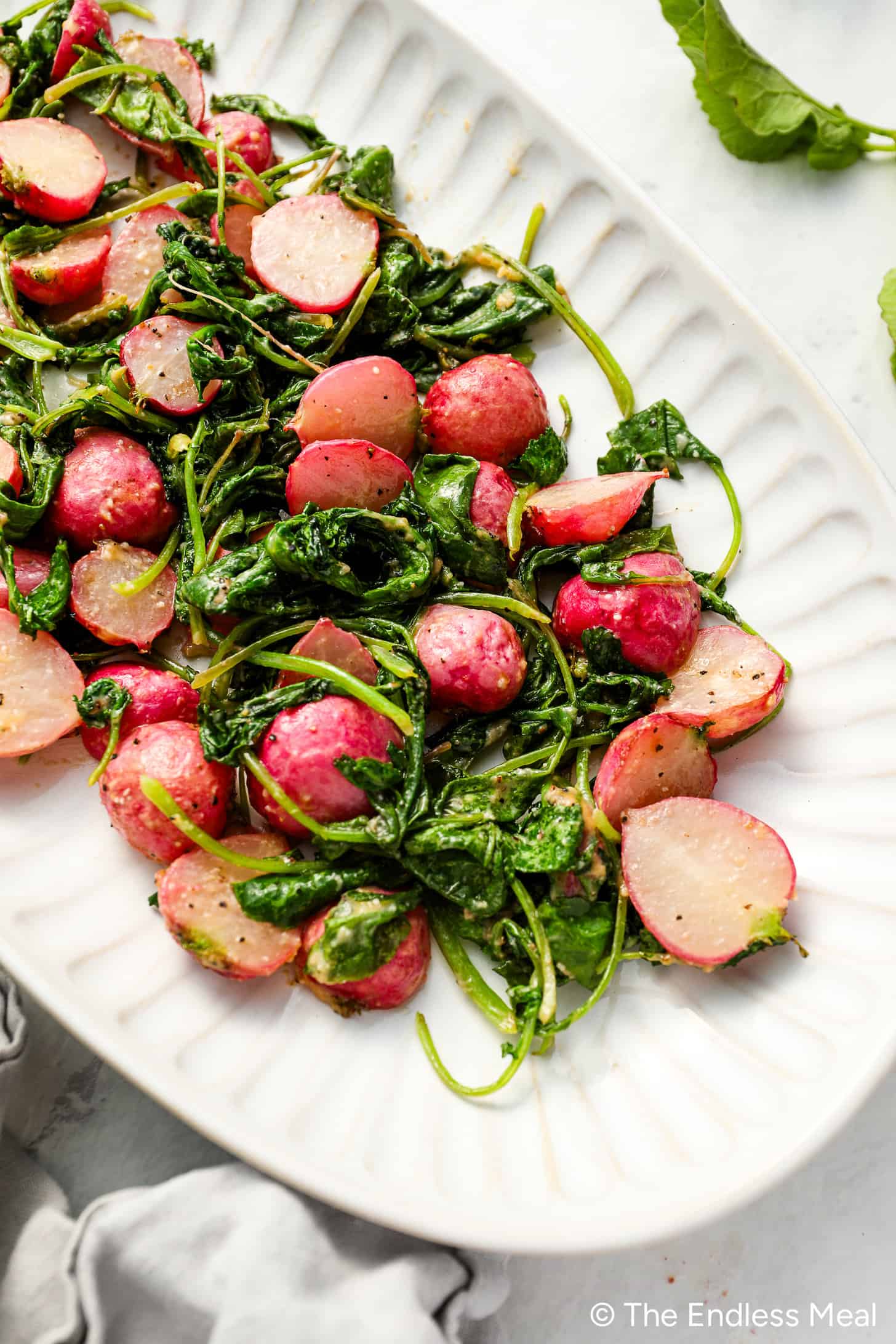 Roasted Radishes with radish greens on a serving plate