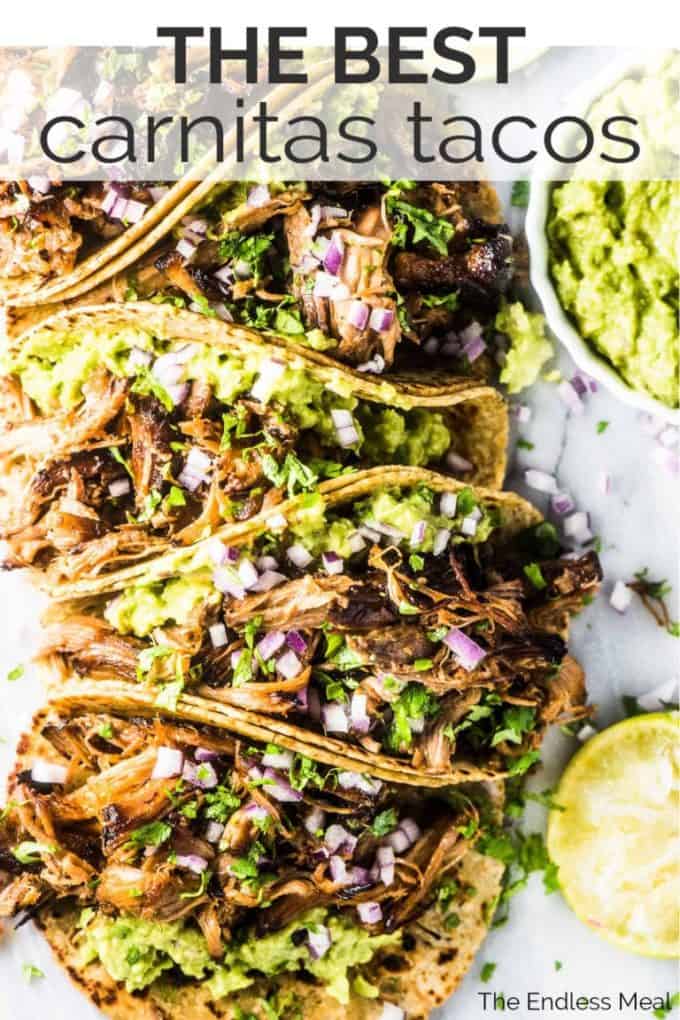 A stack of carnitas tacos on a plate with guacamole and limes beside them and the title at the top of the picture.