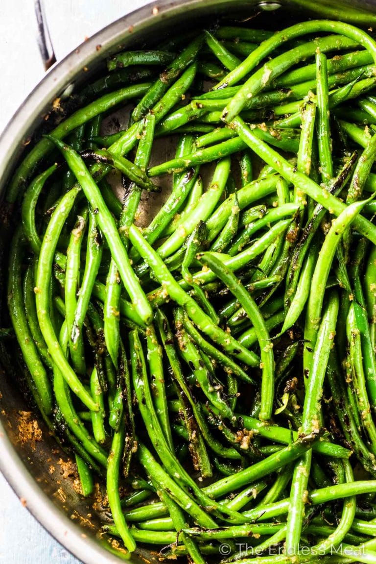 Sauteed green beans with garlic in a skillet.