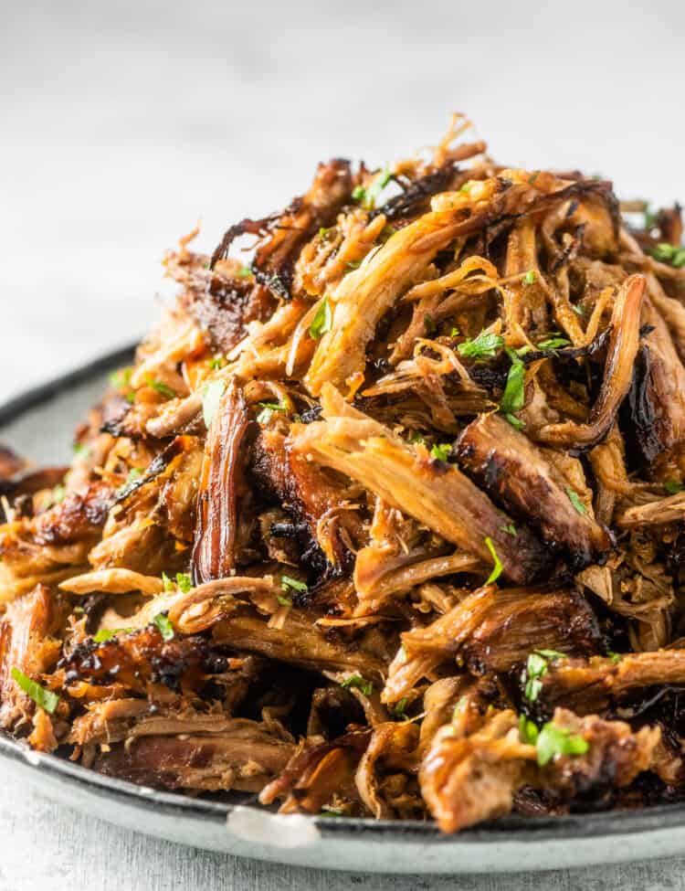 A big pile of Mexican pork carnitas on a plate.